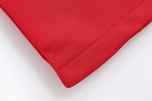 Vue macro du tissu sergé rouge montrant les coutures détaillées et la texture dense