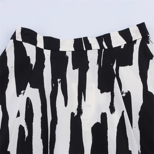 Détail de la taille haute plate et de l'imprimé abstrait noir et blanc d'une jupe chic