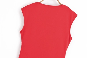 Détail de la robe rouge sans manches montrant la texture côtelée et le col rond élégant