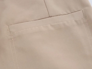 Detailed close-up of khaki blazer pocket with precise stitching and refined fabric texture