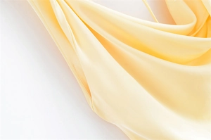 Primo piano della trama in tessuto satinato e delle cuciture premium su un abito color crema