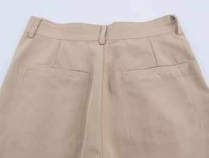 Detailed close-up of khaki trousers back pockets and waist belt loops craftsmanship