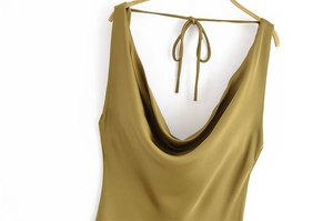 Dettaglio dell'elegante abito in raso verde oliva con scollo a cappuccio e spalline