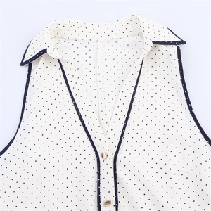 Sleeveless polka dot dress with turn-down collar and V-neck in retro white and black