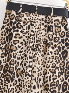 Détail du pantalon léopard taille haute avec une large ceinture noire de style cuir
