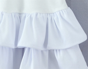 Detail shot of white tiered ruffles and ribbed texture on the spring dress hemline