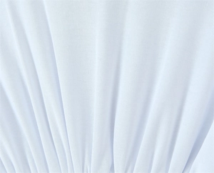 Detailed close-up of white ribbed knit fabric featuring elegant vertical texture and ruffles
