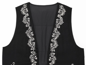 Detail of white embroidery patterns on the edges of a black sleeveless vest top