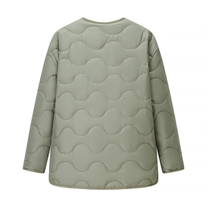Detail of wave quilted stitching and rounded hem on a sage green lightweight jacket