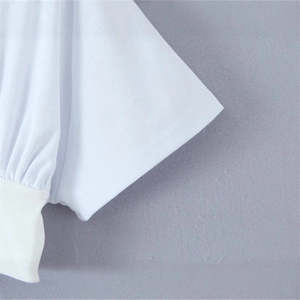 Detail view of white short-sleeve dress showing ribbed cuffs and neat stitching lines