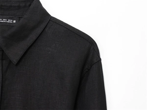 Detail shot of black linen shirt showing collar stitching and Cambodia origin label