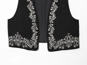 Close-up of black cotton vest featuring intricate white bohemian floral embroidery detailing