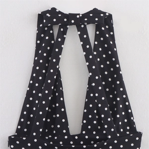 Dettaglio dello scollo all'americana con fiocco a pois e spalline incrociate sul vestito