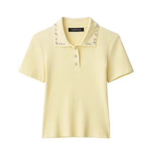 Close-up of light yellow ribbed knit polo shirt featuring sparkling rhinestone collar decor