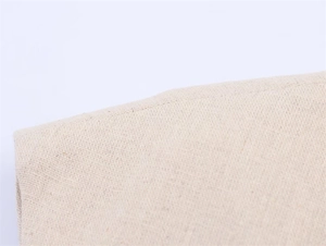 Détail du tissu en coton et lin beige clair montrant la texture naturelle et la couture