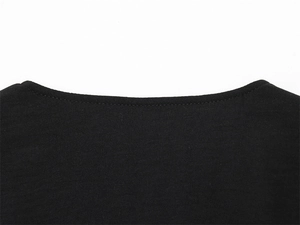 Detail view of the round neckline on a black vest featuring smooth knit fabric texture