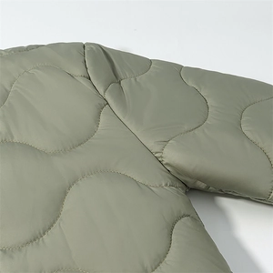 Close-up of olive green onion-quilted jacket showing fine shoulder seam stitching details