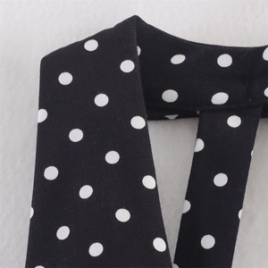 Dettaglio ravvicinato del tessuto a pois bianco e nero per un abito estivo all'americana