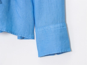 Detail of sky blue linen shirt showing wide double-stitched cuffs and woven texture