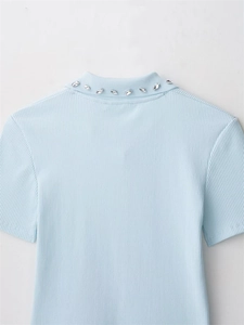 Close-up of light blue knit top with ribbed texture and rhinestone collar details