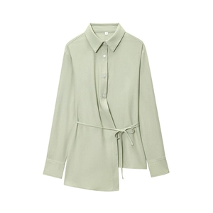 Detail of mint green long sleeve shirt featuring asymmetric hem and adjustable waist tie