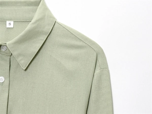 Close-up of lapel collar and buttons on sage green long-sleeved casual shirt