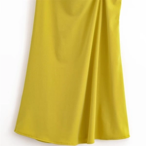 Close-up of bright yellow knit dress hem showing fine stitching and draped fabric texture