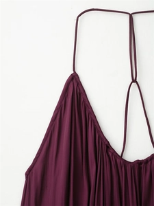 Détail des bretelles fines et du tissu plissé d'une robe moulante violet foncé