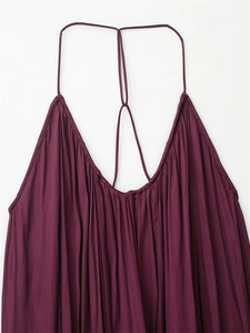 Détail d'une robe caraco plissée violet foncé avec de fines bretelles et un décolleté froncé