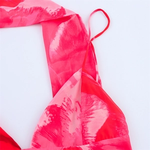 Détail d'une robe fleurie rouge avec fines bretelles et texture en mousseline