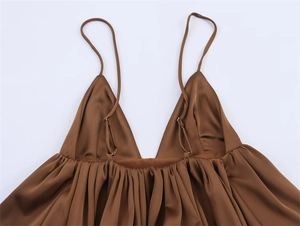 Detail of brown satin camisole featuring delicate pleats and adjustable thin straps