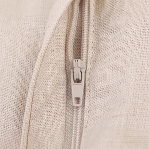 Gros plan du tissu en coton et lin beige montrant les coutures et la fermeture éclair