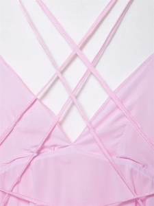 Detail shot of pink dress featuring intricate criss-cross straps and smooth satin fabric