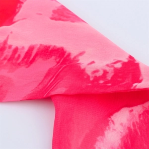 Gros plan sur l'imprimé foulard rose et rouge avec détails de texture en mousseline