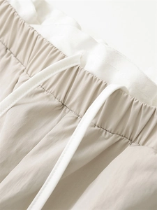 Detail shot of elastic waist and white drawstring on light khaki wide-leg casual pants