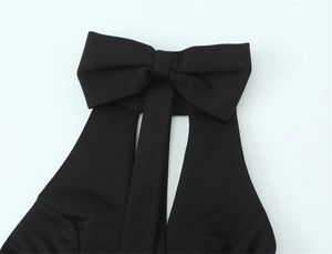 Détail d'une robe dos nu noire avec un grand nœud décoratif et une découpe élégante