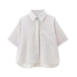 Detail view of striped short sleeve shirt featuring front pocket and curved hemline