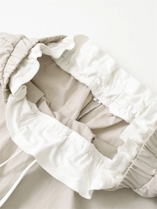 Detail of khaki wide-leg pants featuring double-layered elastic waistband and white drawstrings
