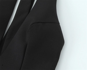 Détail de la couture d'épaule sur une robe noire cintrée avec tissu texturé raffiné