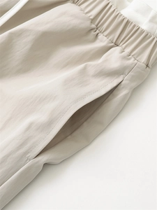 Detail of high elastic waistband and side pocket on beige wide leg casual trousers