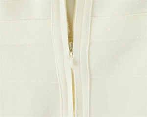 Détail macro du tissu en maille blanc crème et de la fermeture éclair invisible lisse