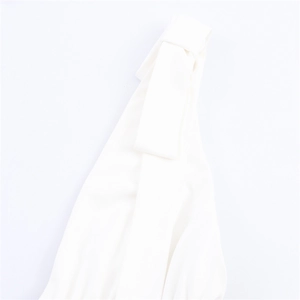 Detailed macro view of white chiffon dress showing intricate knot and buckle design