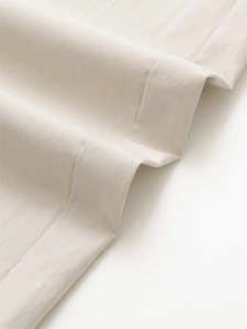 Detailed macro view of beige wide-leg trousers showing premium twill fabric and stitching