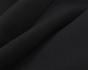 Gros plan sur la texture d'un tissu textile noir de qualité avec des drapés élégants