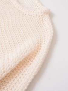 Close-up of cream white coarse knit sweater showing neckline detail and textured pattern