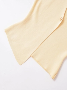 Detailed texture of light yellow knit sweater with vertical ribbing and gold button
