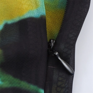 Macro shot of the black invisible zipper on colorful tie-dye print summer dress fabric