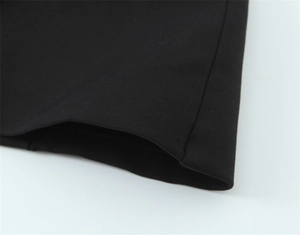 Détail du tissu en maille élastique et de l'ourlet à double couture sur robe noire
