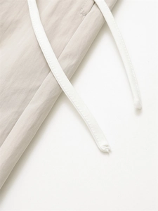 Detail of waist design on casual wide-leg pants featuring white flat drawstrings