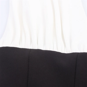 Detail of contrast stitching and pleated texture on a black and white fashion dress